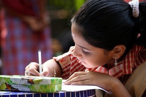 tyttö tekee kotiläksyjä