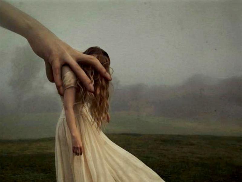 suuri käsi riepottelee naista