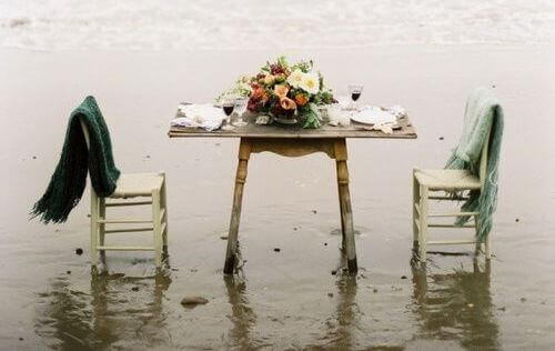 rantavedessä on pöytä ja tyhjät tuolit