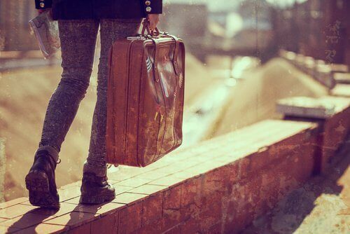 nuori ihminen kantaa matkalaukkua