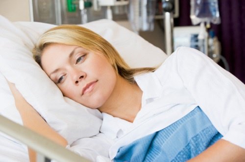 nainen makaa sairaalapedissä