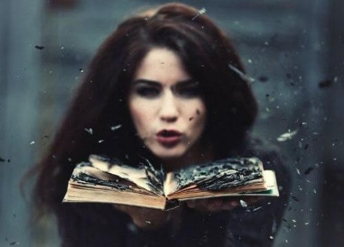 nainen puhaltaa poltettua kirjaa