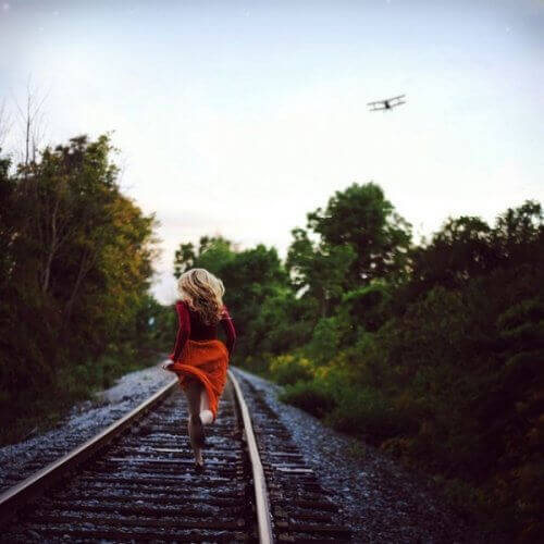 nainen juoksee rautatiellä