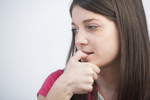 nainen pureskelee kynsiään