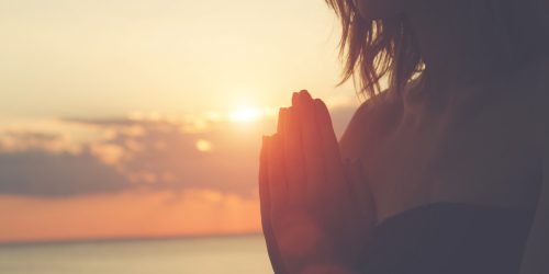 nainen meditoi ilta-auringossa