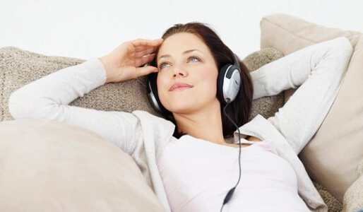 rentoutunut nainen kuuntelee musiikkia