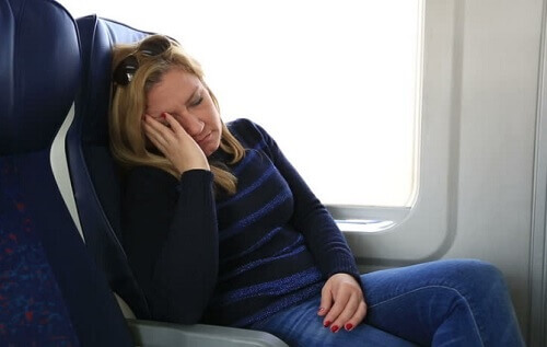 nainen yrittää nukkua lentokoneessa