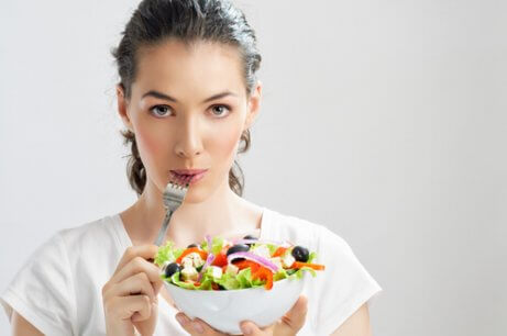 nainen syö salaattia välttääkseen epigastralgia