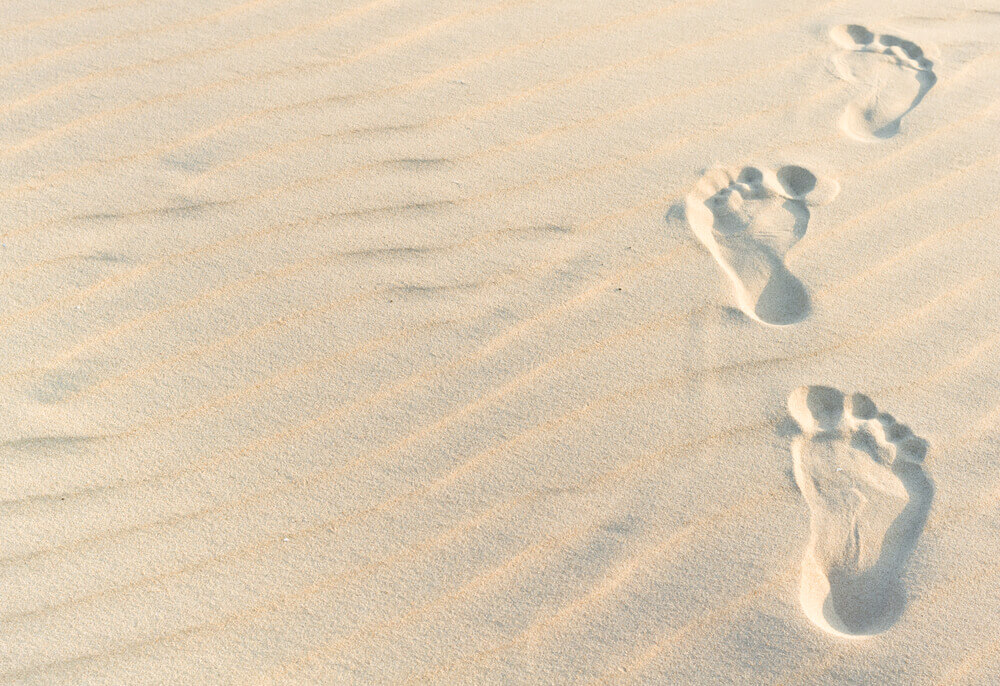 yhdet jalanjäljet hiekassa