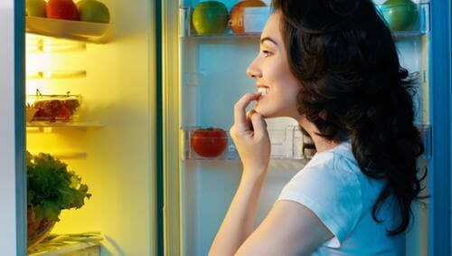 nainen himoaa ruokaa jääkaapista
