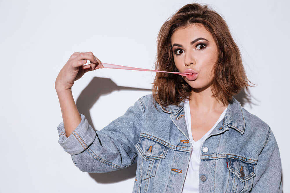 tyttö venyttää purukumia