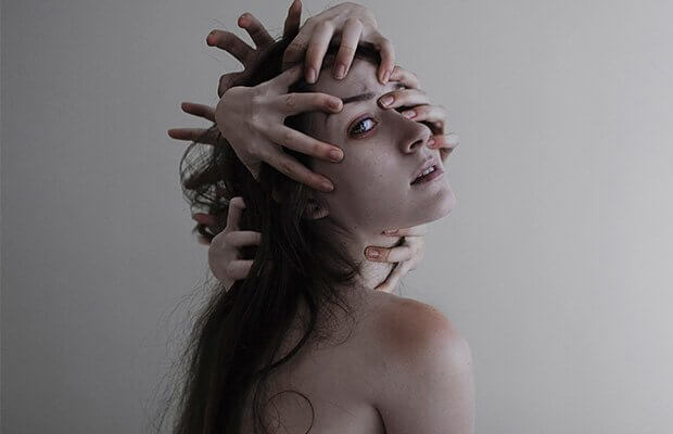 kädet naisen päässä