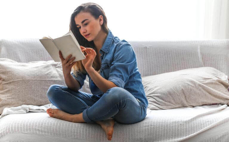 tyttö lukee sohvalla