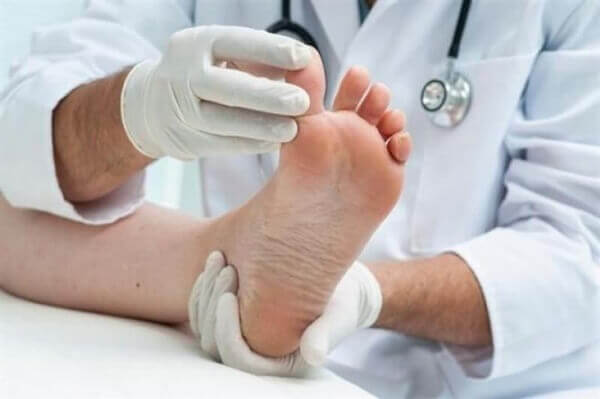 lääkäri tutkii potilaan jalkoja