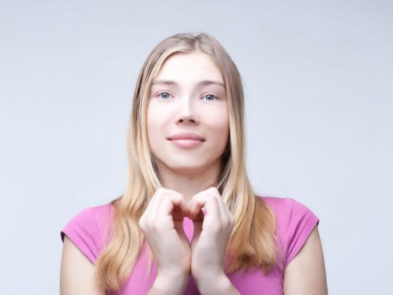 nainen tekee sydämen käsillään