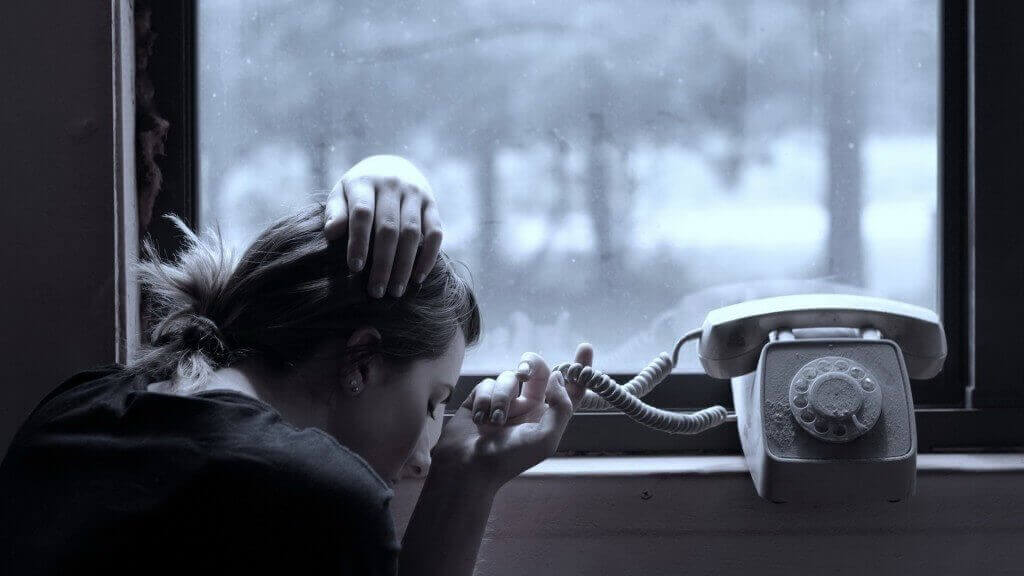 nainen odottaa puhelinsoittoa