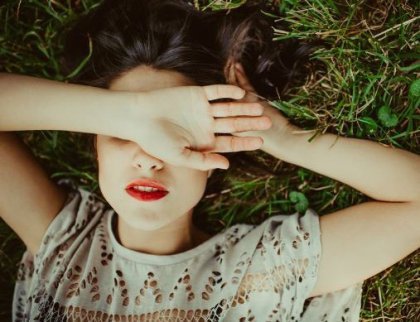 Nainen peittää silmänsä