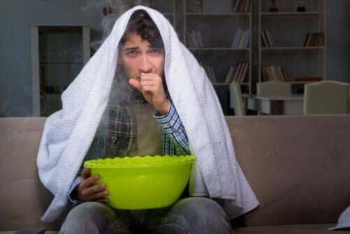 Mies hengittää höyryä.