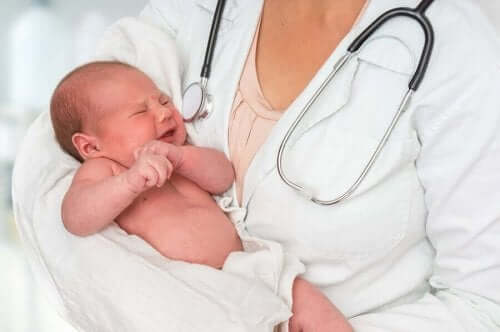 Vauva lääkärin käsivarsilla.