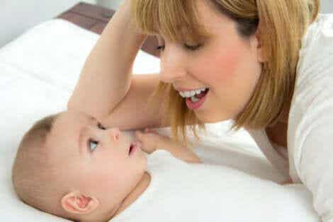 Äiti haluaa leikkiä vastasyntyneen kanssa.