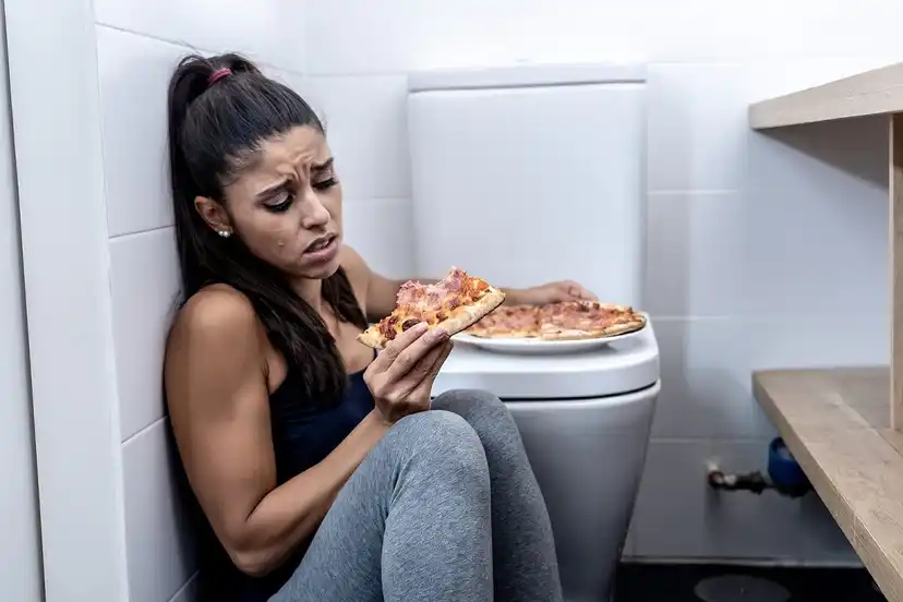 Nainen kokee syyllisyyttä pizzan syömisestä.